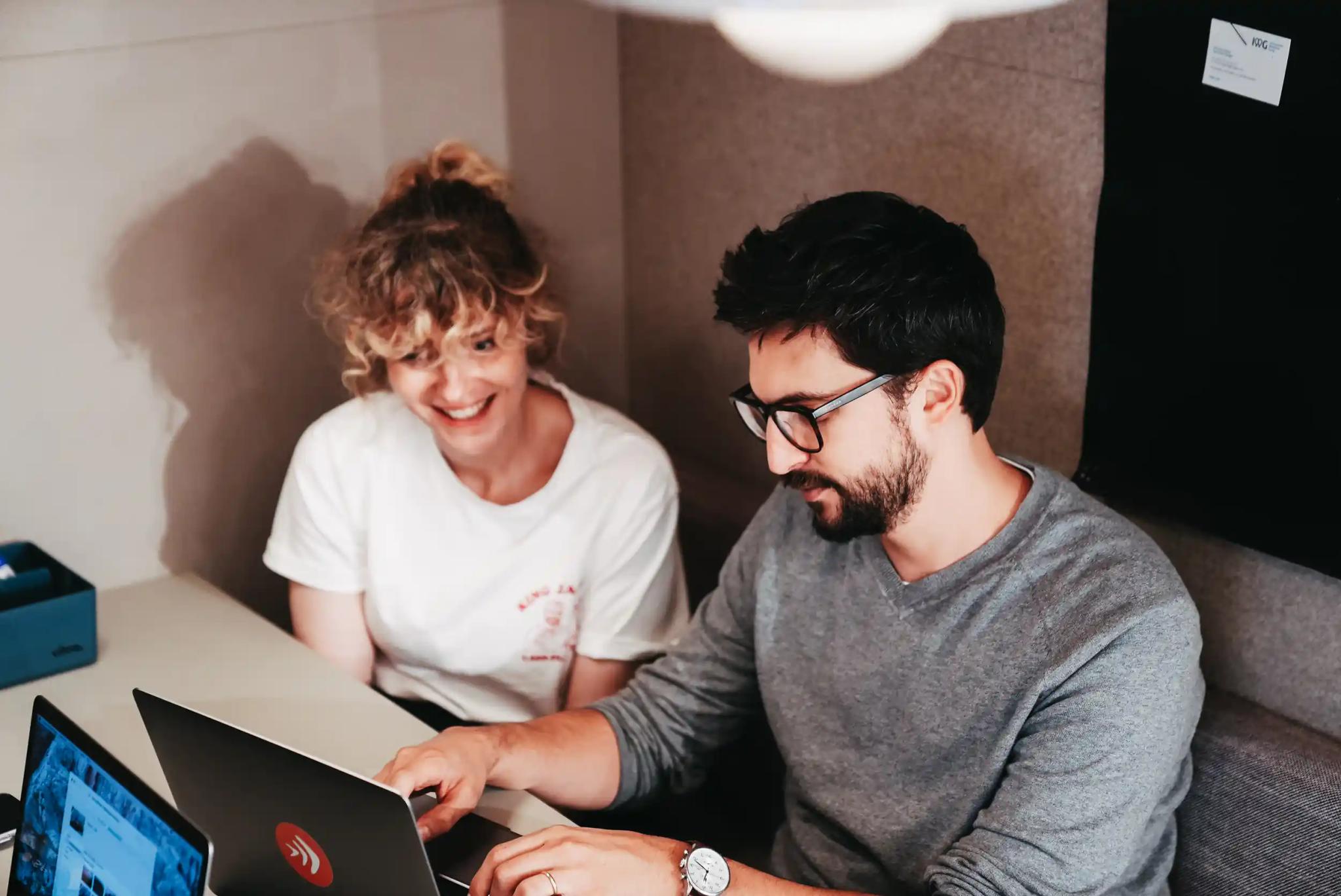 Two people working together on a laptop.