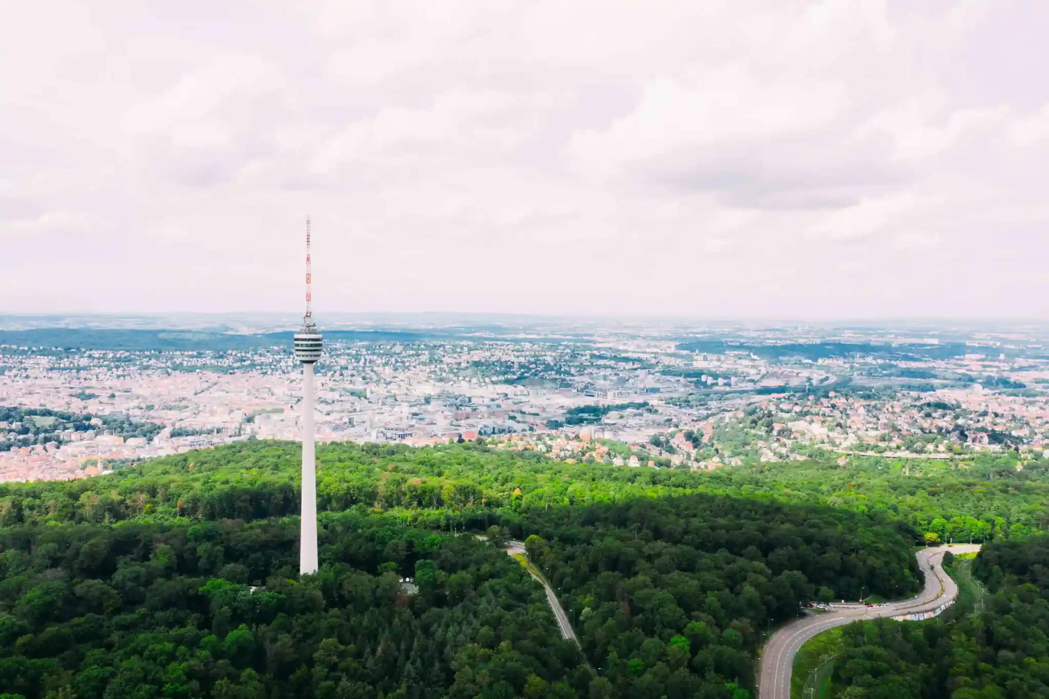 TV tower in a forest with city in the background