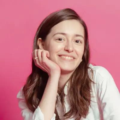 Portrait of a smiling woman against pink background