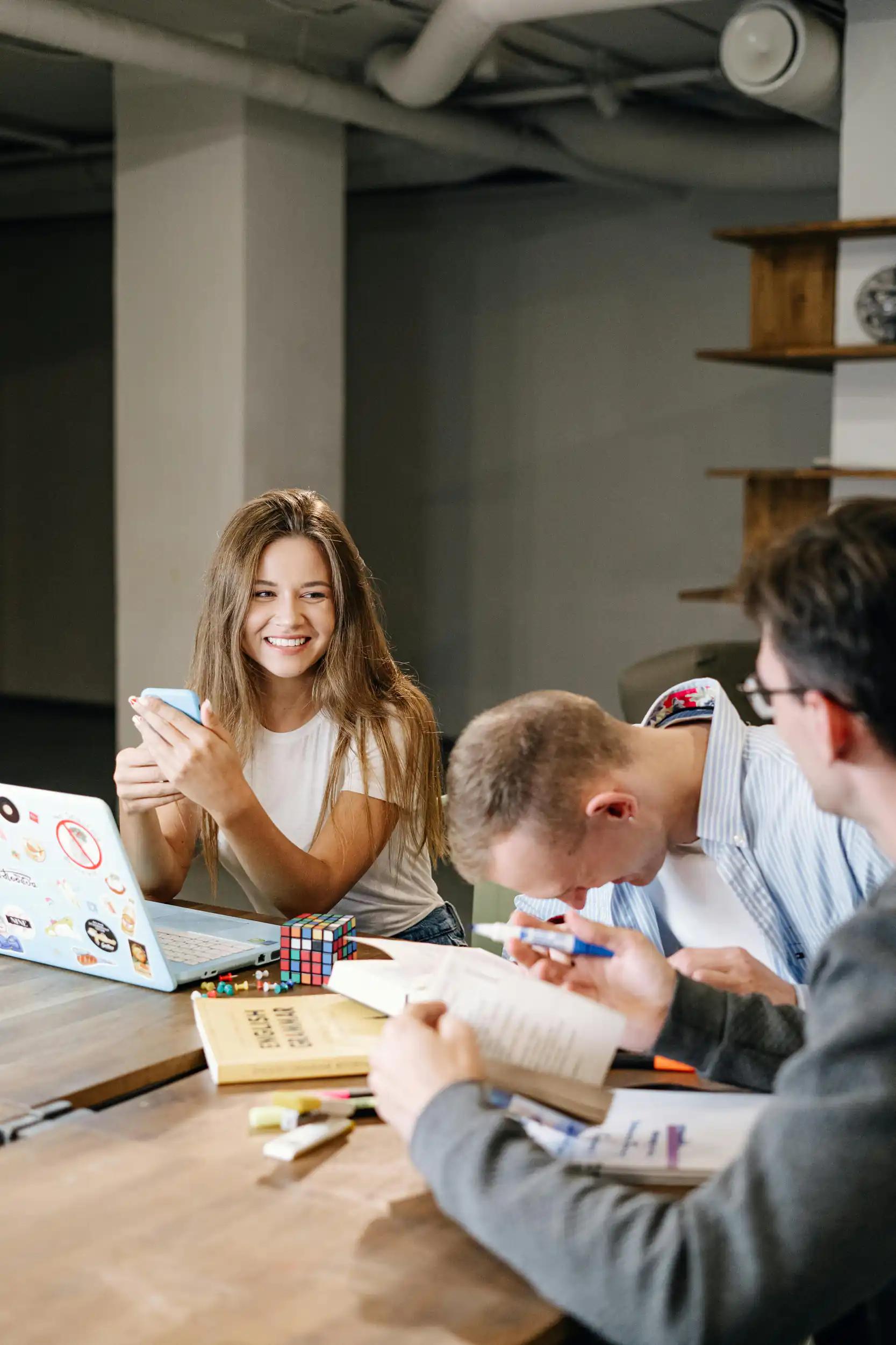 Young people studying and laughing together at a table.