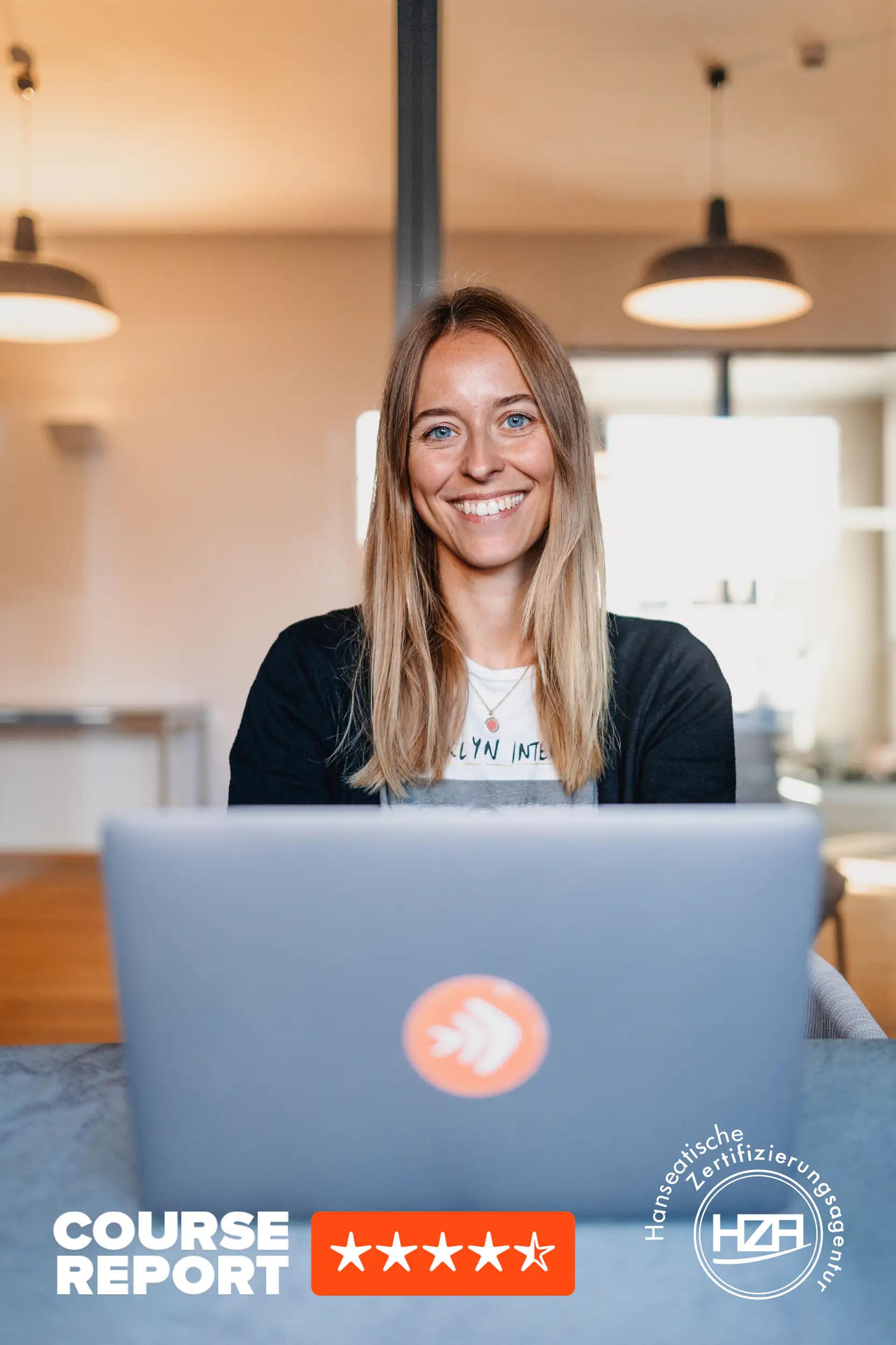 Frau lächelt am Laptop im Büro
