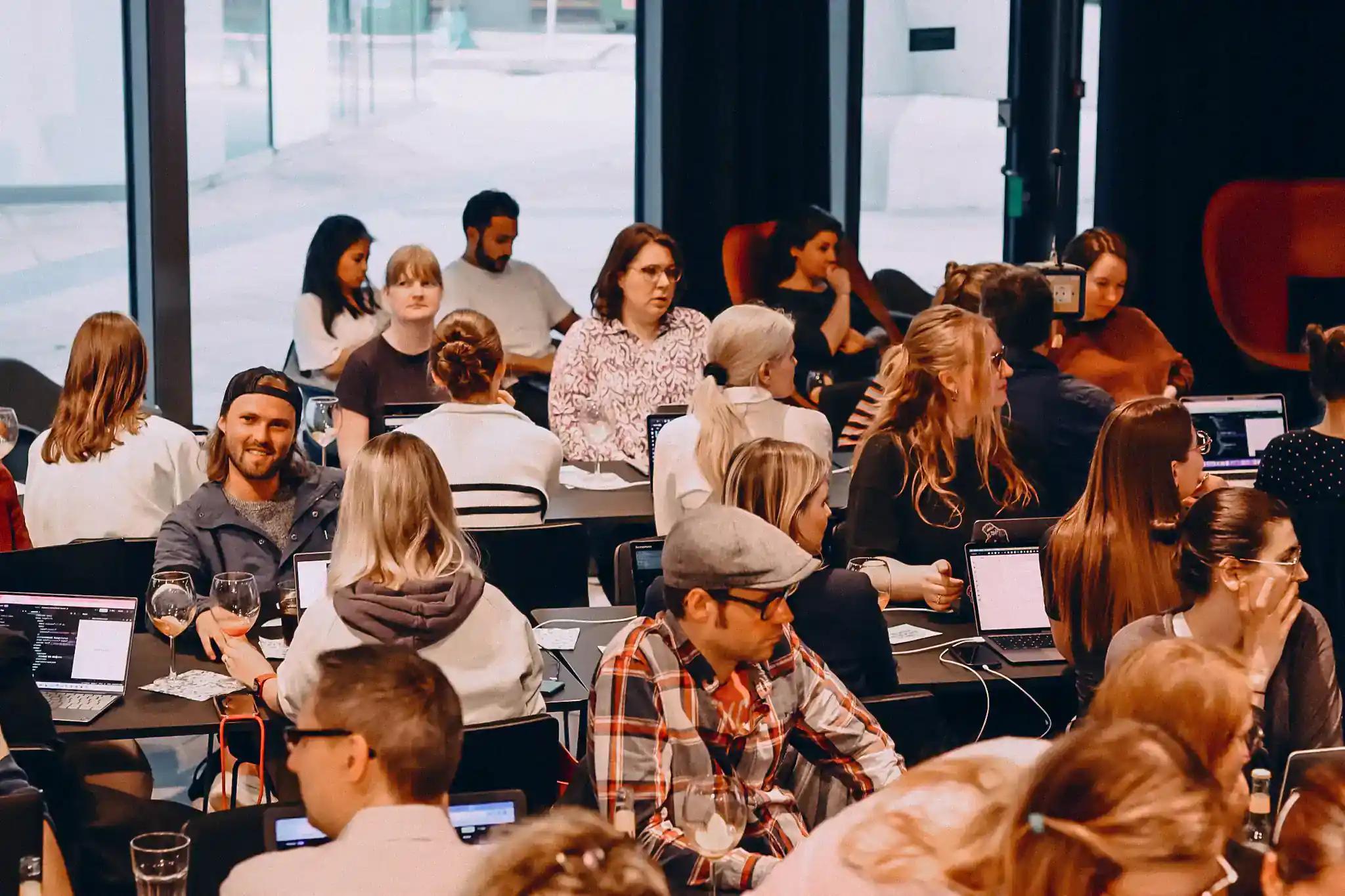 People in a busy café with laptops.