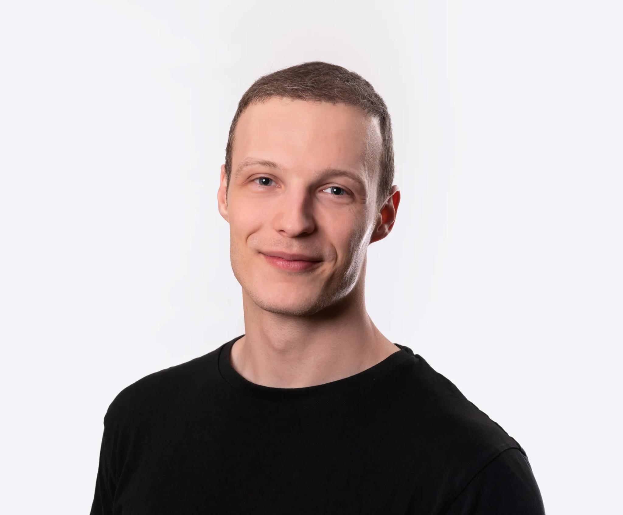 Portrait of a smiling young man against a white background.