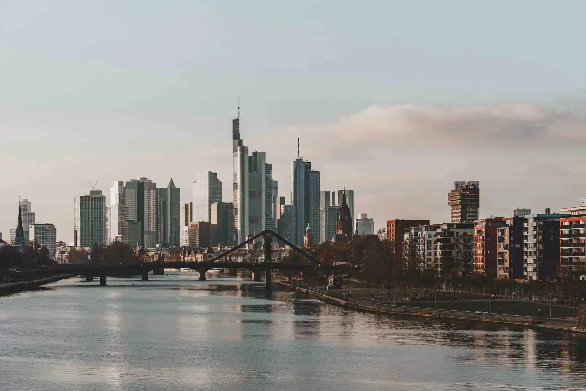 Stadtansicht mit Fluss und Brücke bei klarem Himmel.
