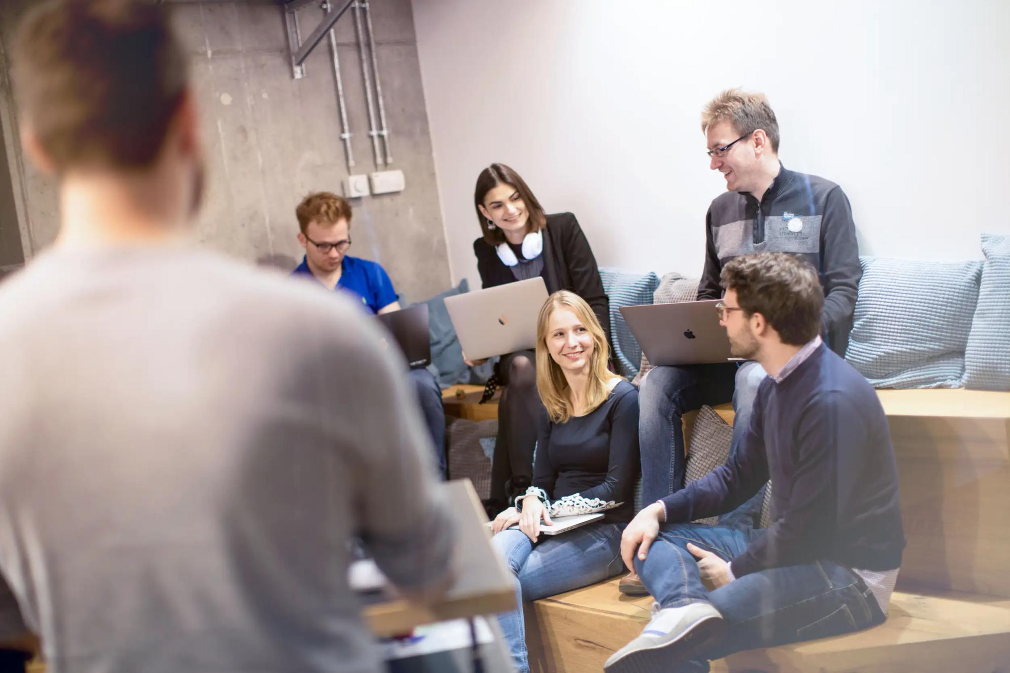People in an informal meeting with laptops.