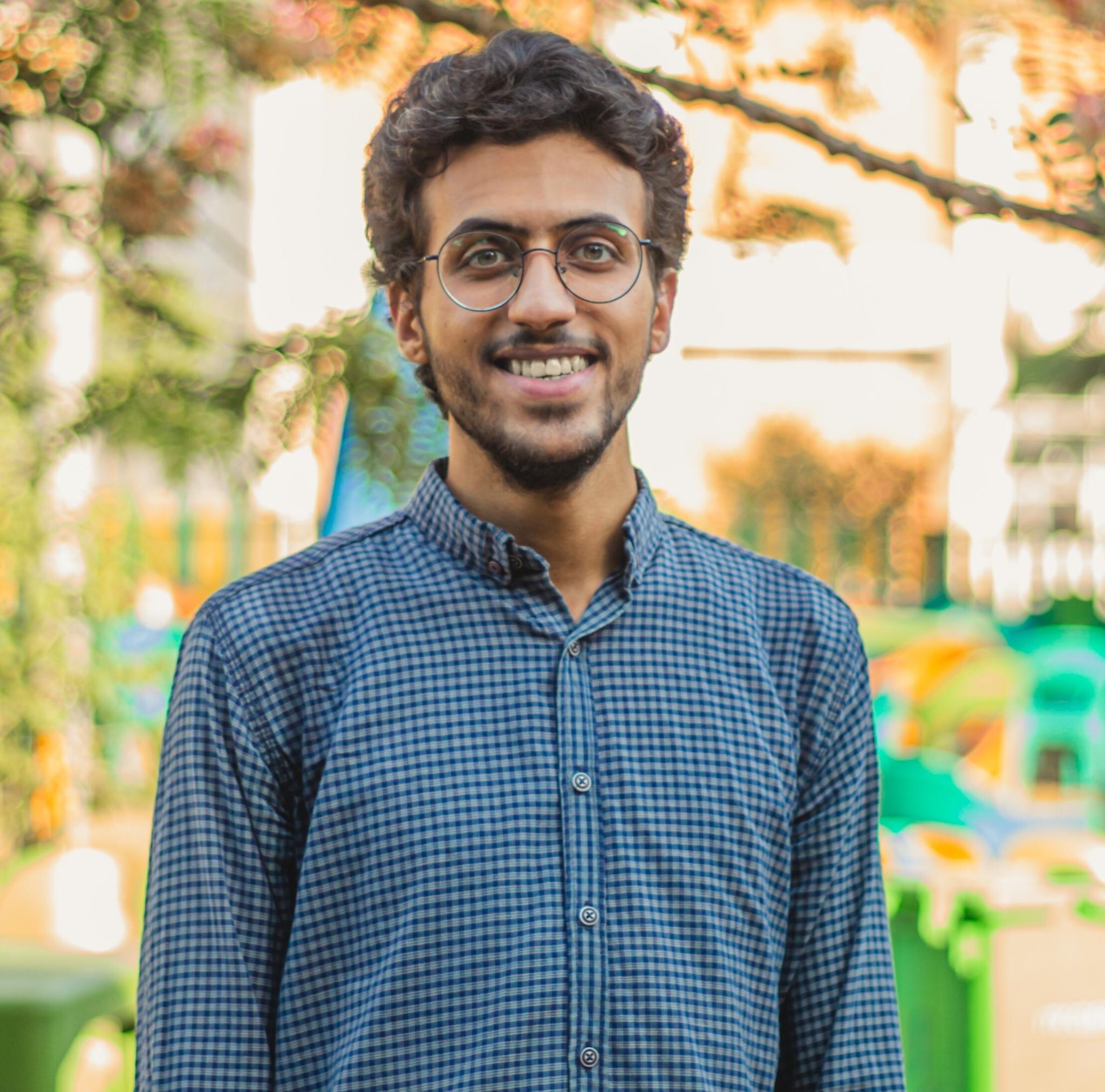 Smiling man with glasses outdoors