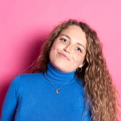 Woman with curly hair against pink background