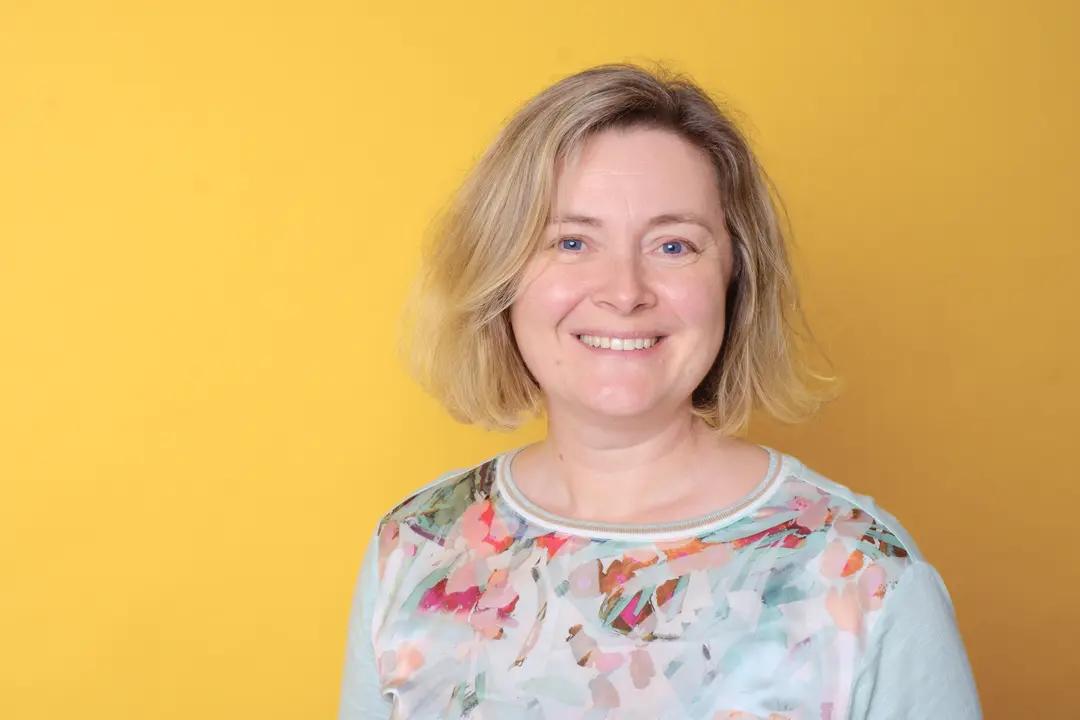 Portrait of a smiling woman against yellow background