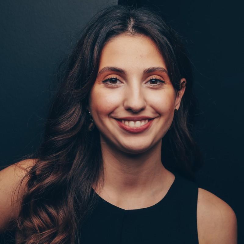 Portrait of a smiling woman against a dark background