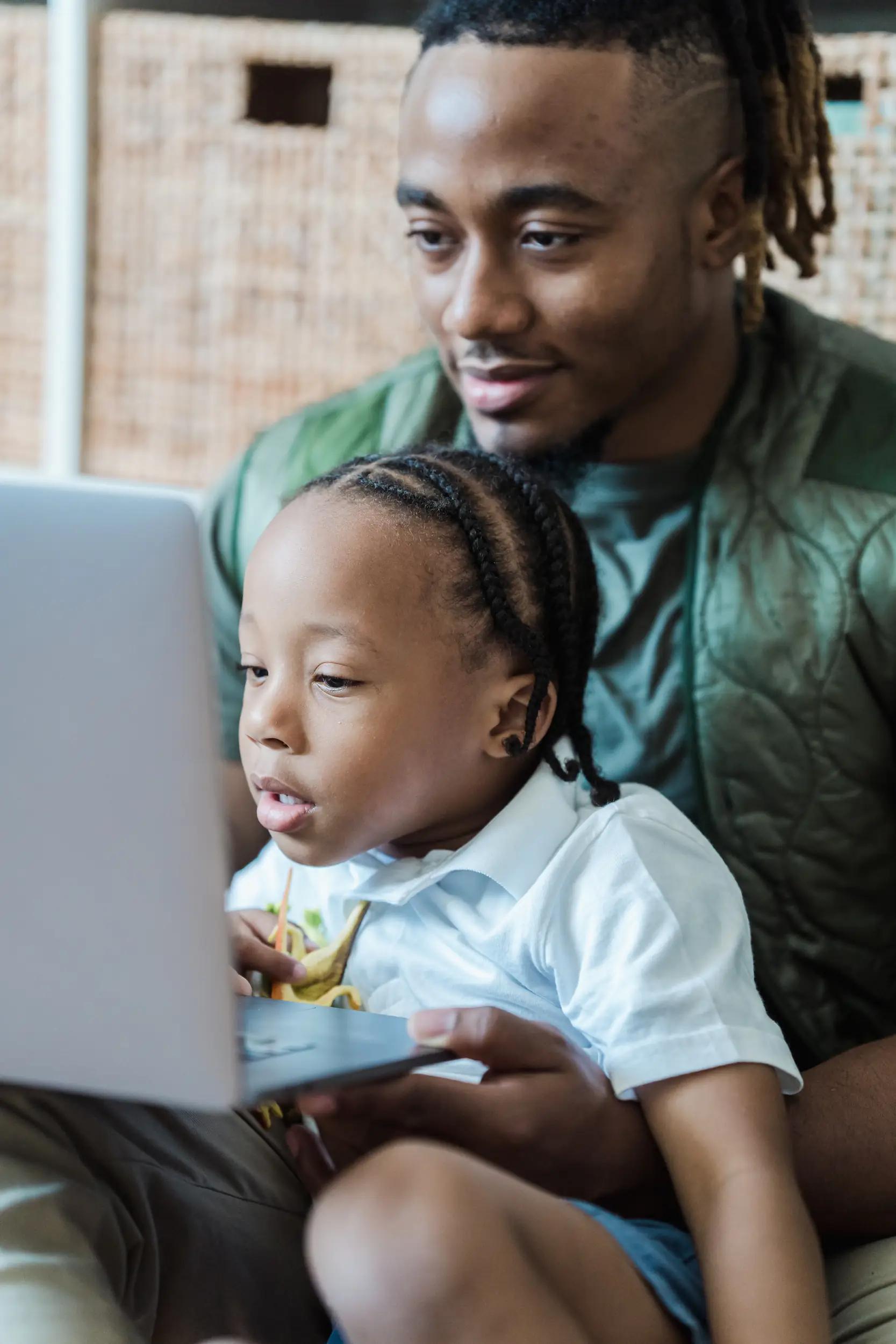 Man and child looking at a laptop.