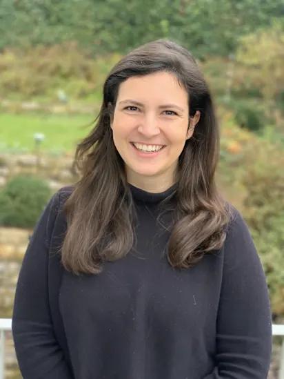 Smiling woman with long dark hair outdoors