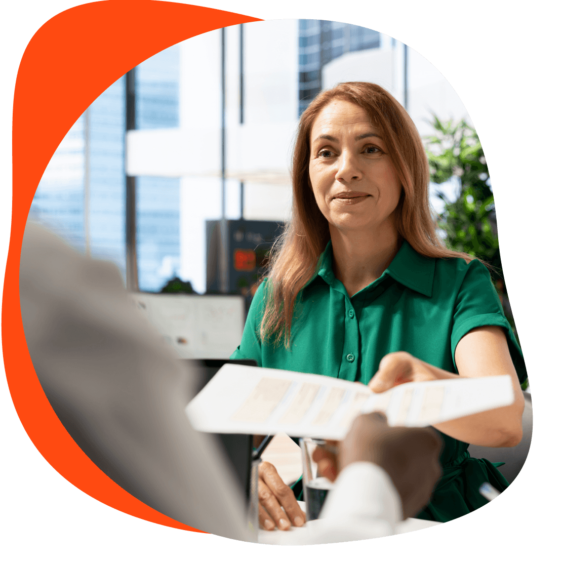 Woman handing over a document in an office.