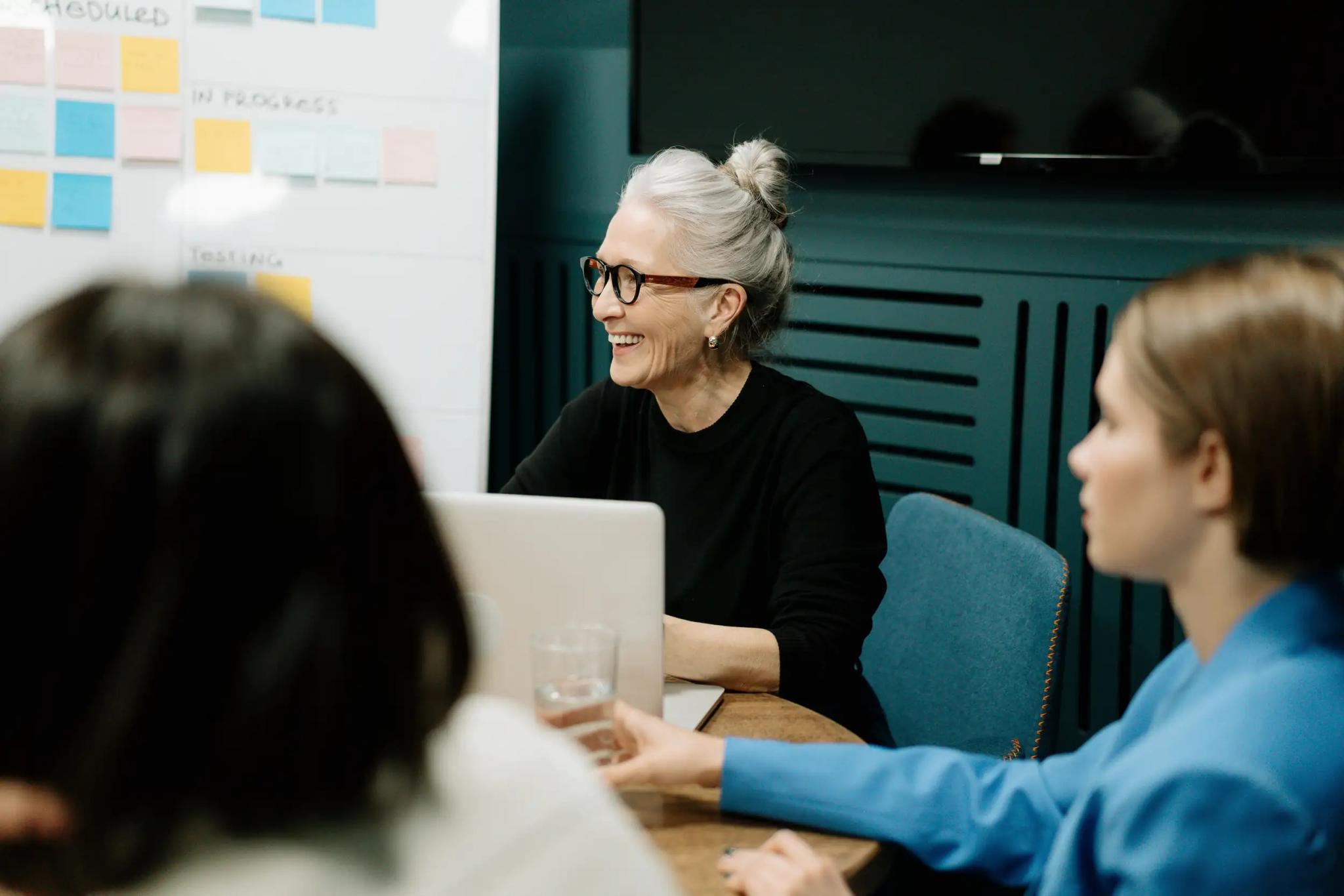 Older woman discussing with colleagues in office