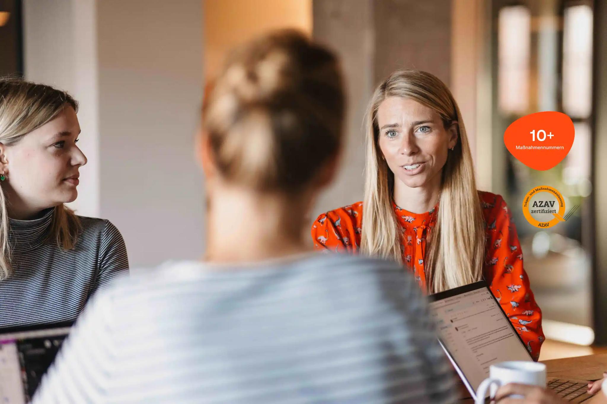 Three women having a conversation in an office