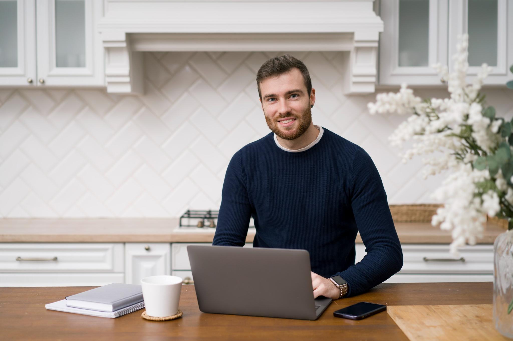 Man at laptop in kitchen