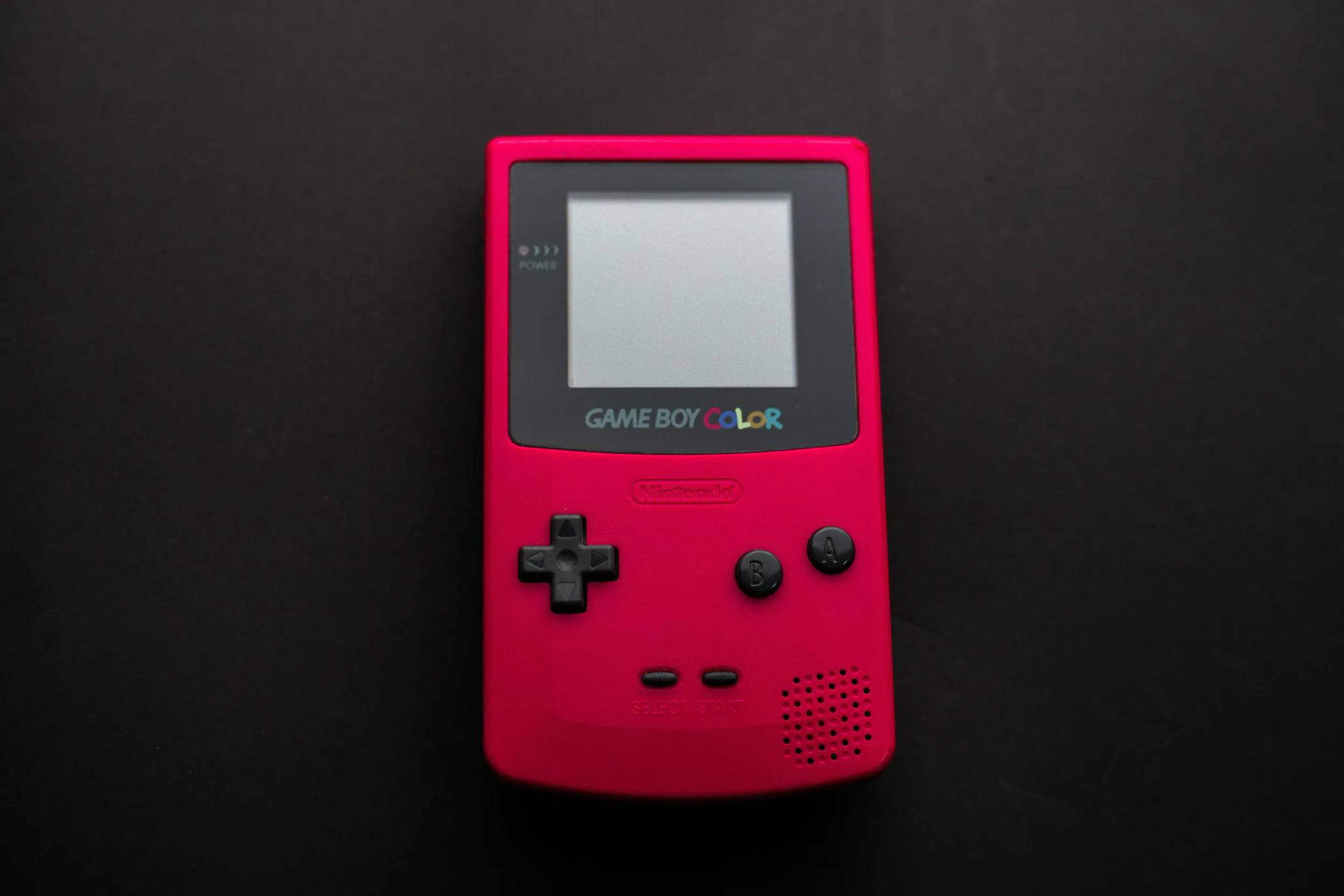 Red Game Boy Color on black background.