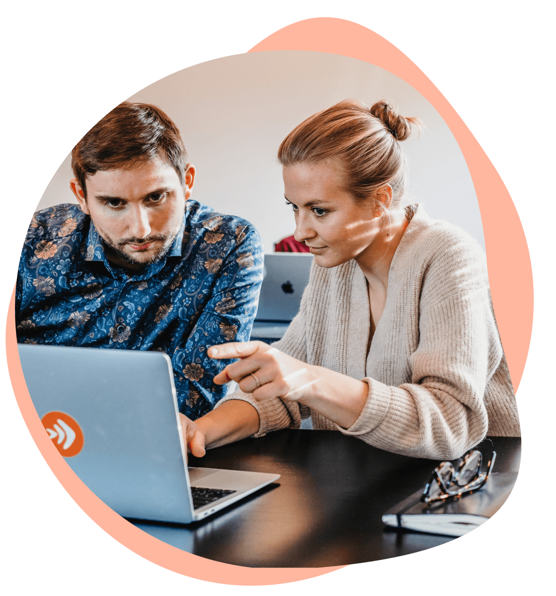 Two people working together on a laptop.