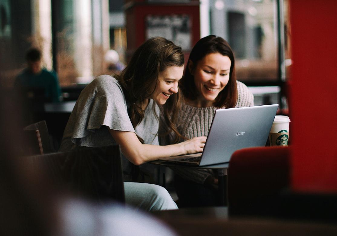 Two women working together on a laptop.