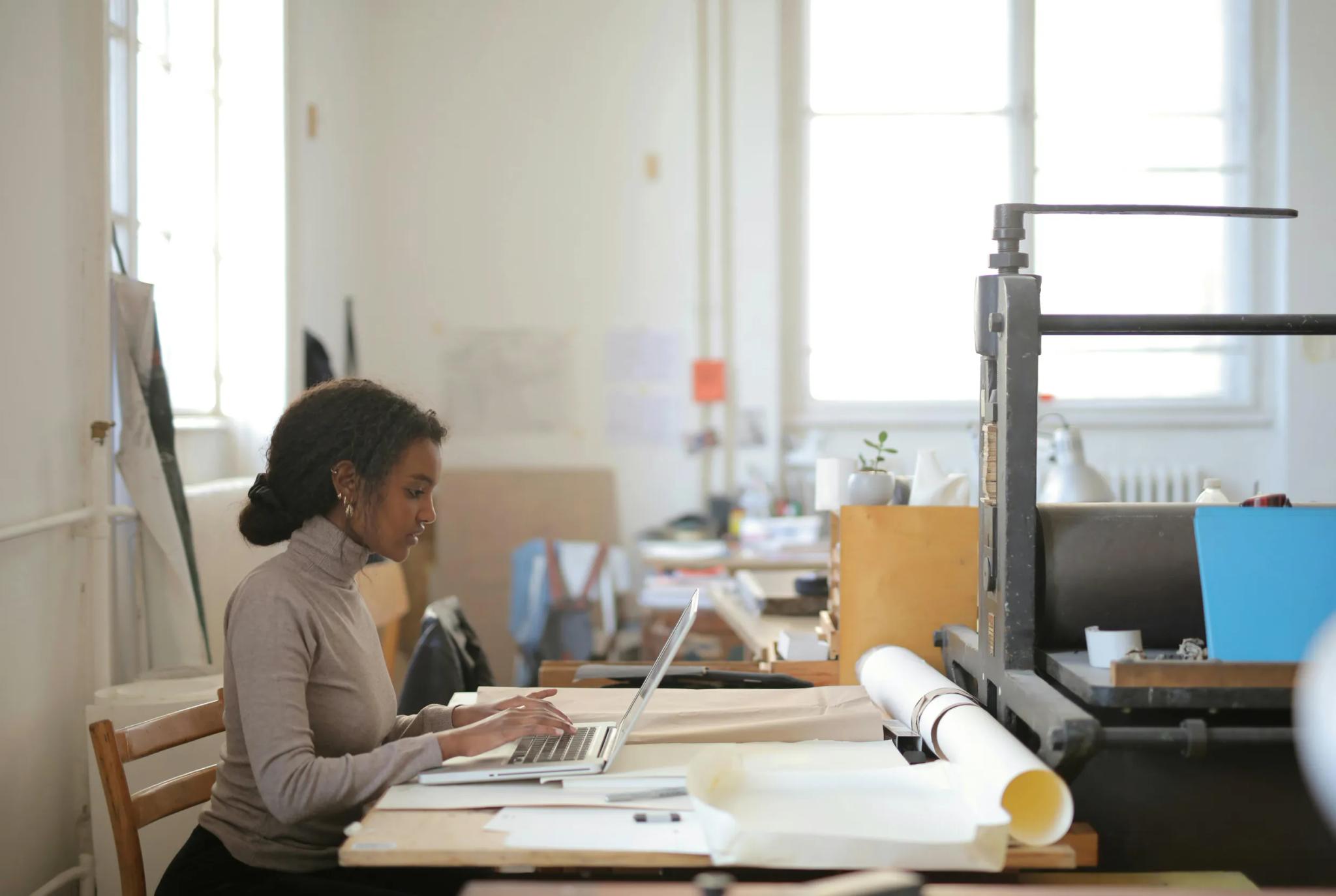 Woman working on a laptop in a studio.