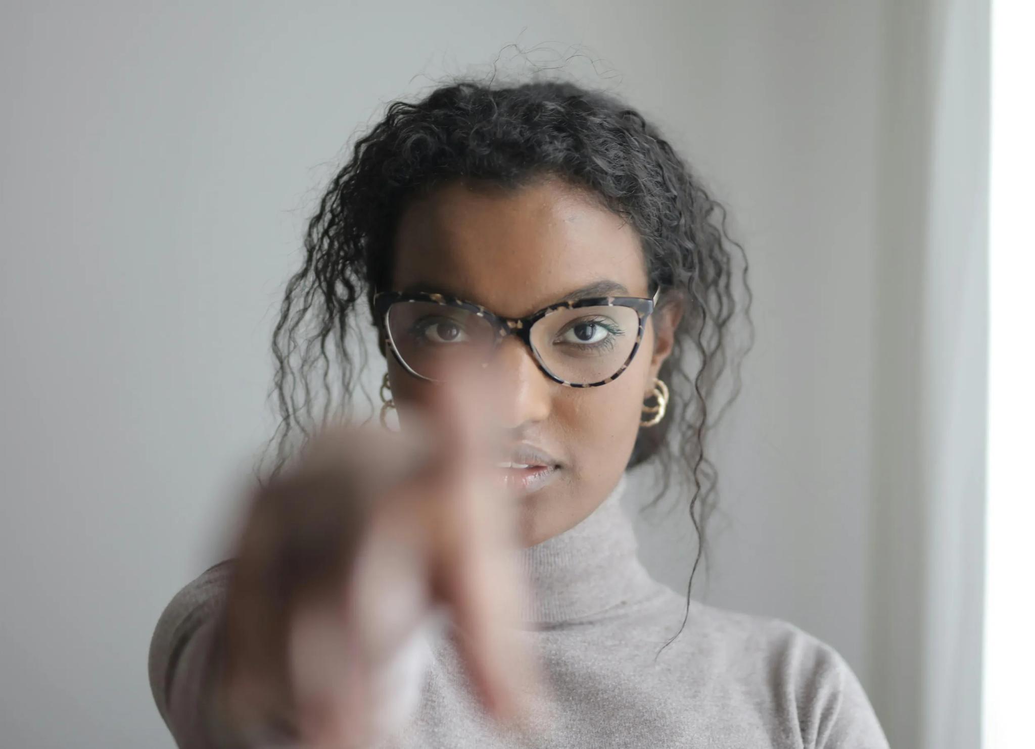 Frau mit Brille zeigt auf die Kamera