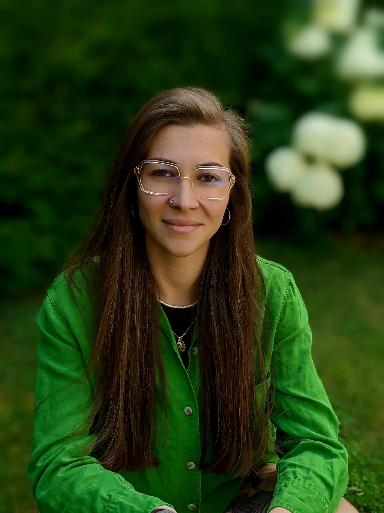 Woman with glasses and green shirt outdoors