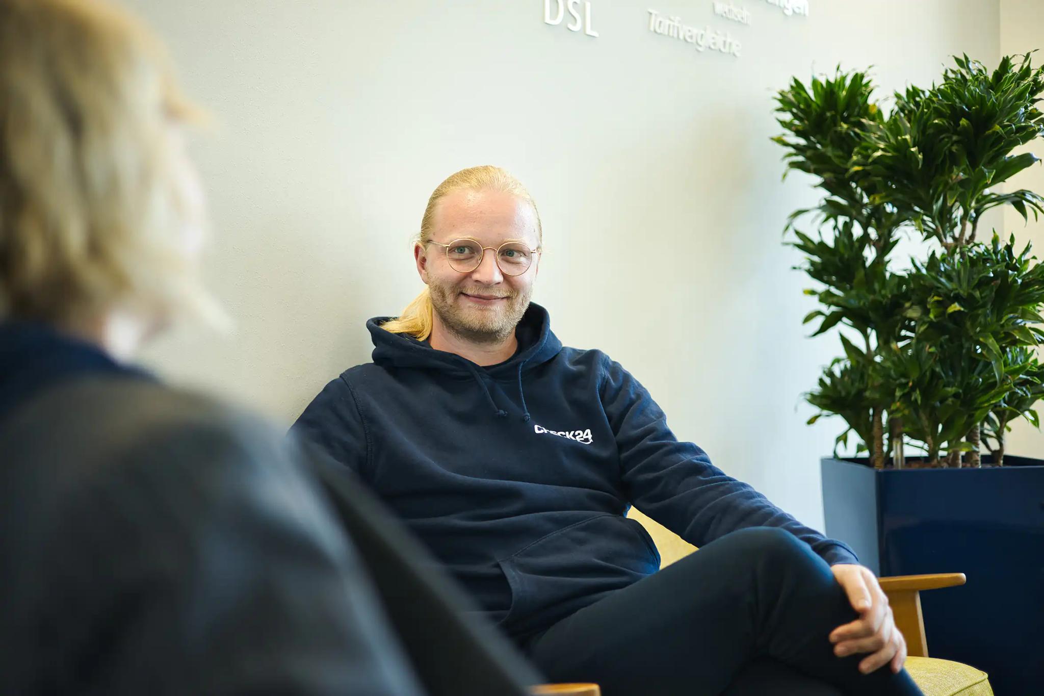 Zwei Personen im Gespräch in einem modernen Innenraum.