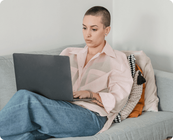 Person sitting on a sofa working on a laptop.