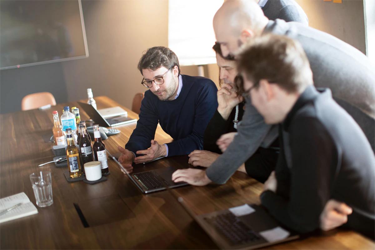 Group of people working together on a laptop.