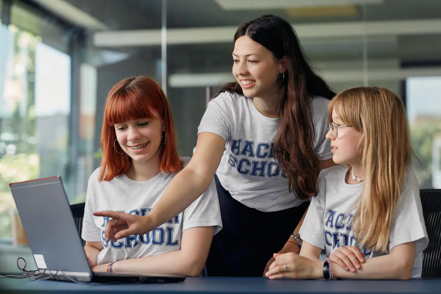 Three female students at a laptop in school.