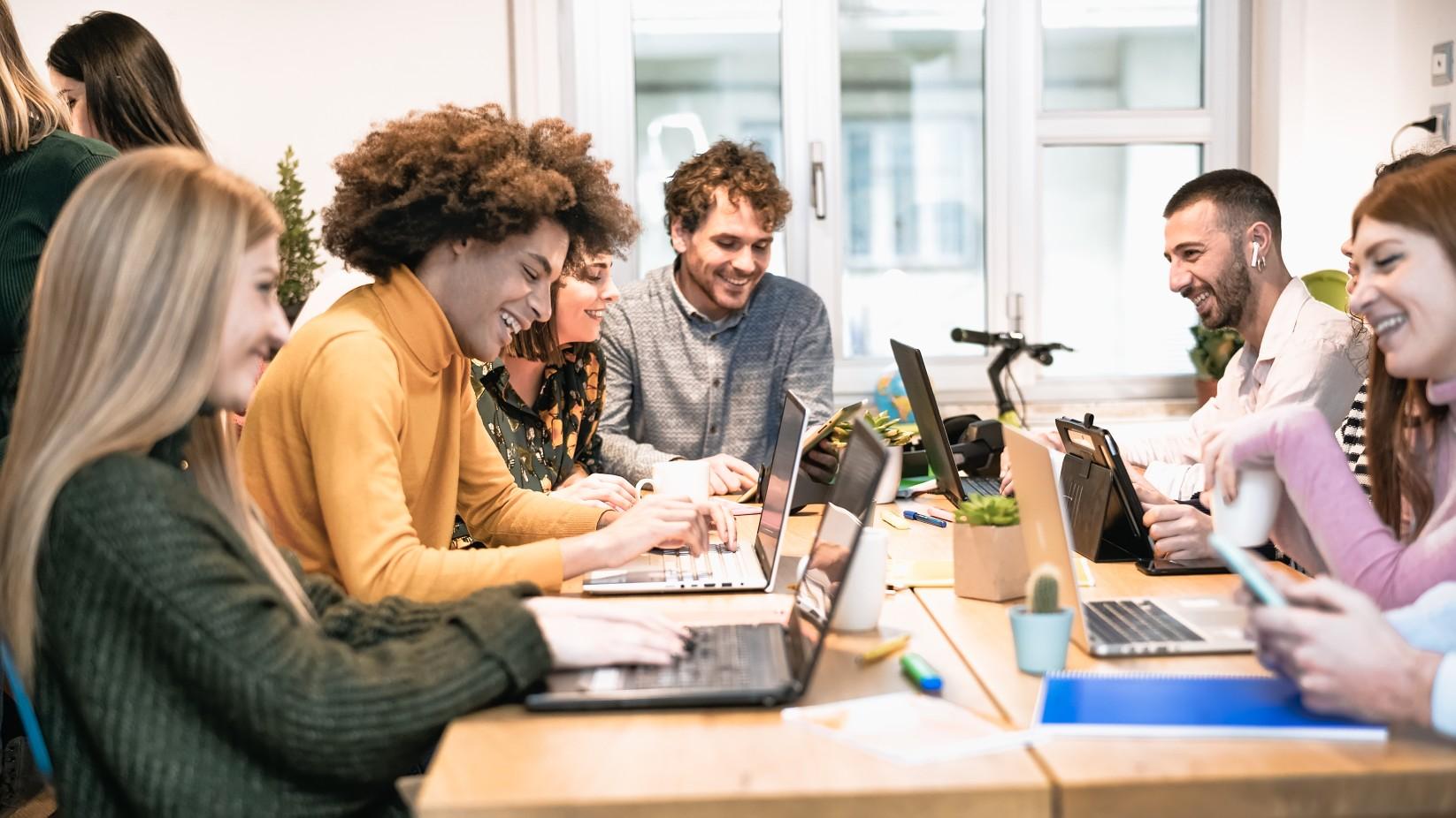Gruppe junger Menschen arbeitet und lernt gemeinsam mit Laptops.