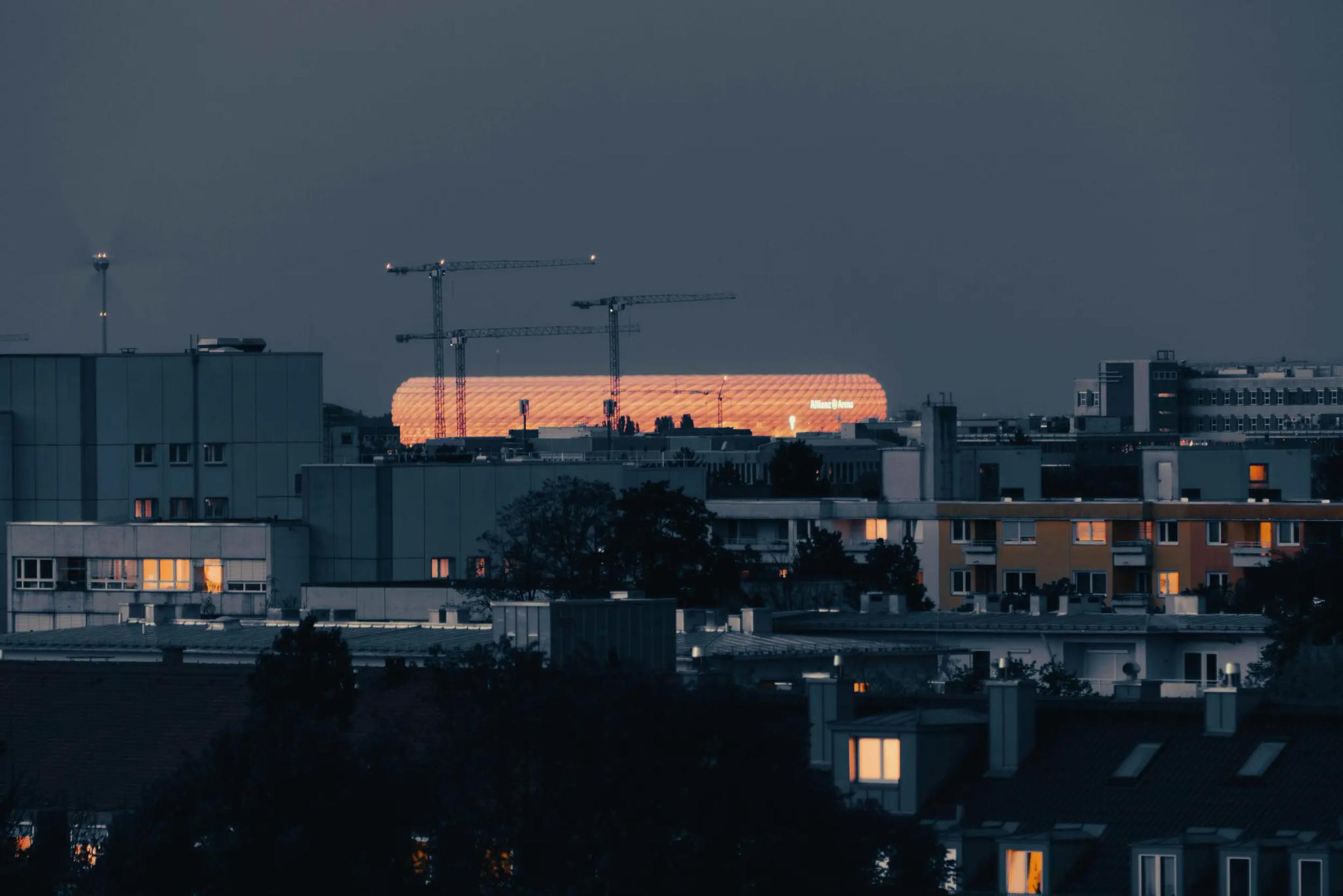Cityscape at sunset with buildings and cranes