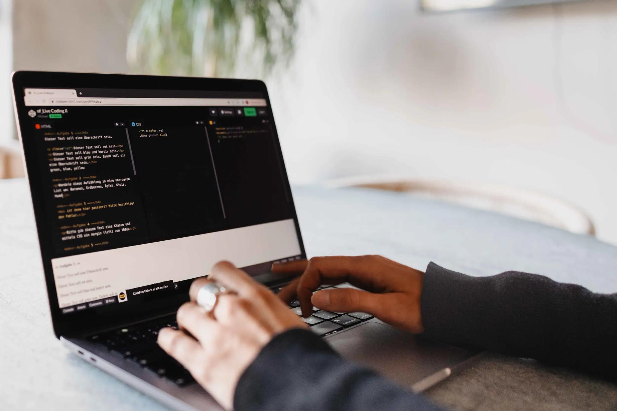 Person typing code on a laptop.
