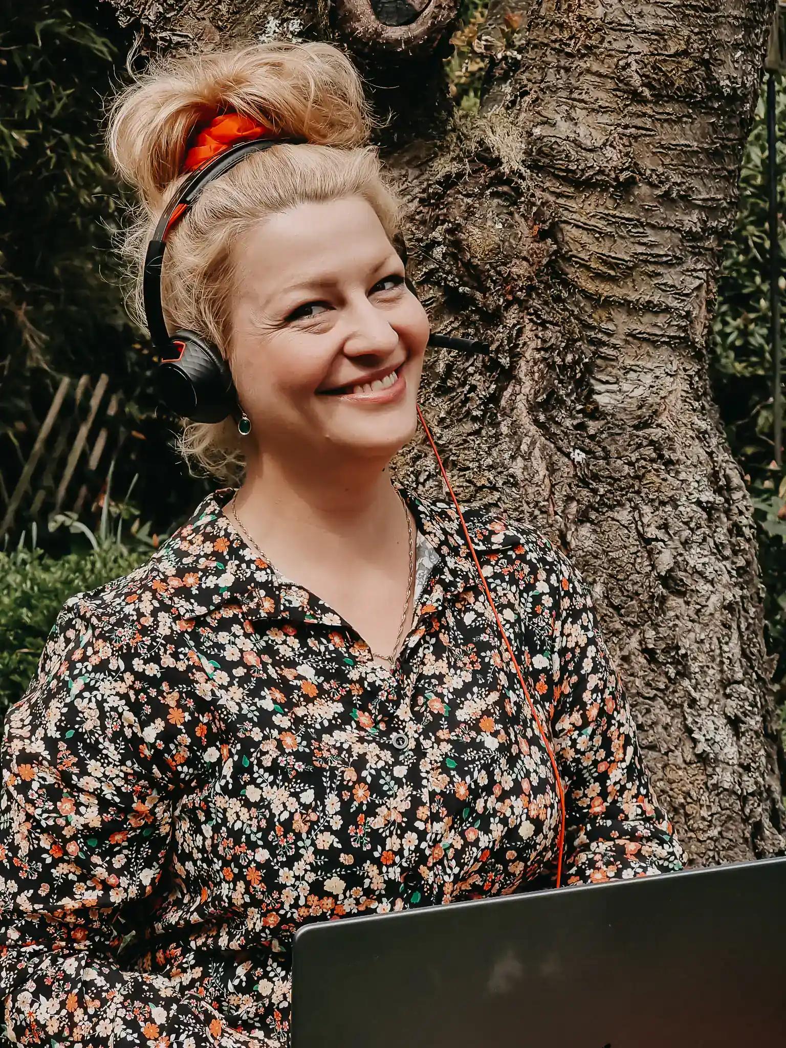 Woman with headphones and laptop outdoors