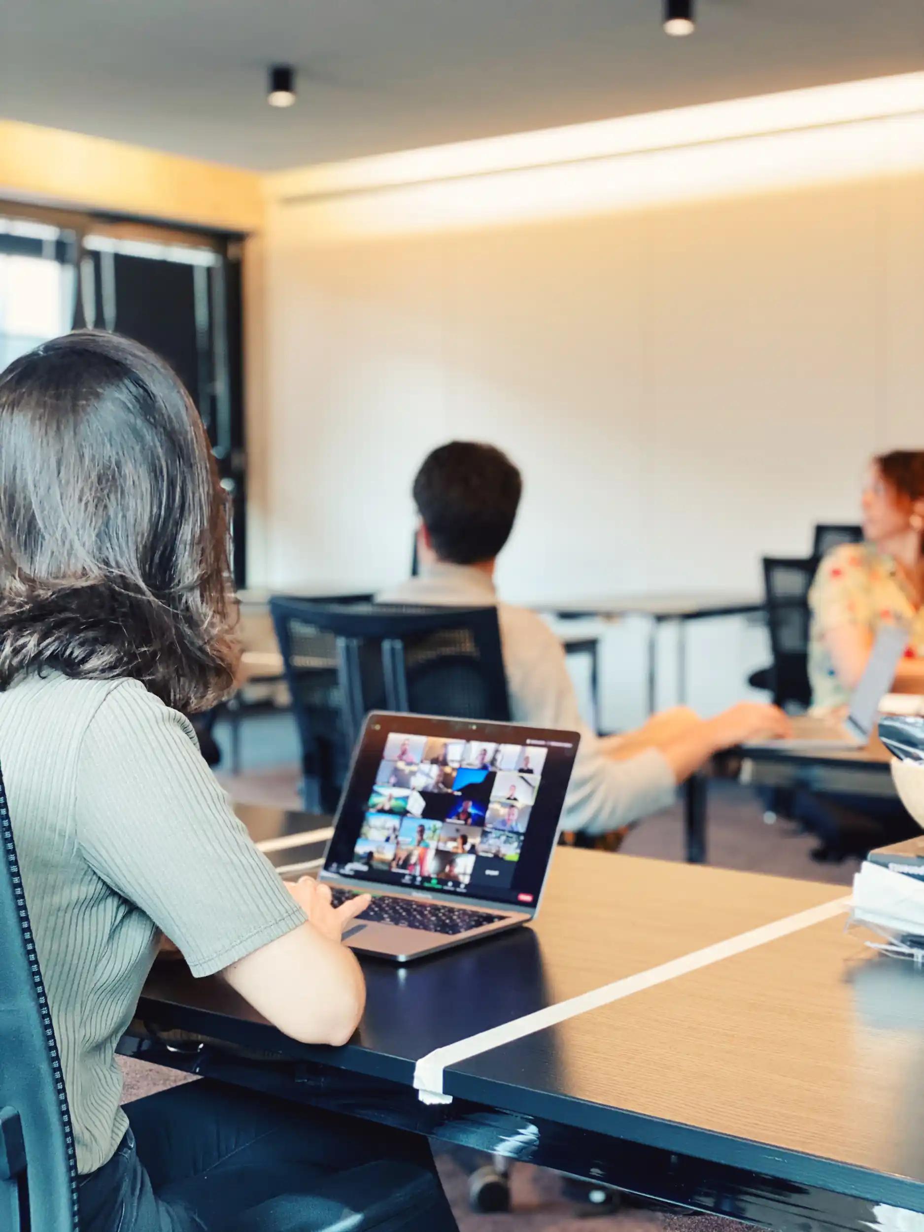 Person using laptop with video conference in office