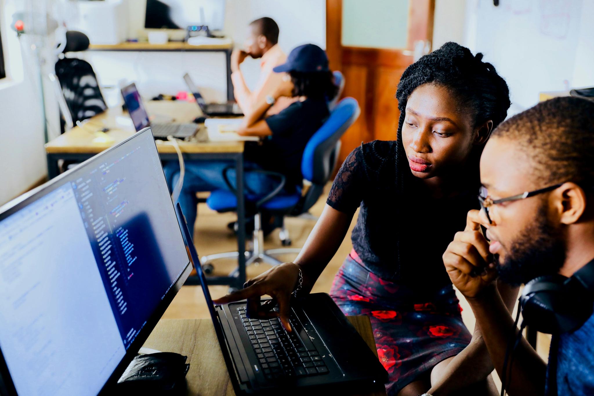Colleagues working together on a computer in an office.