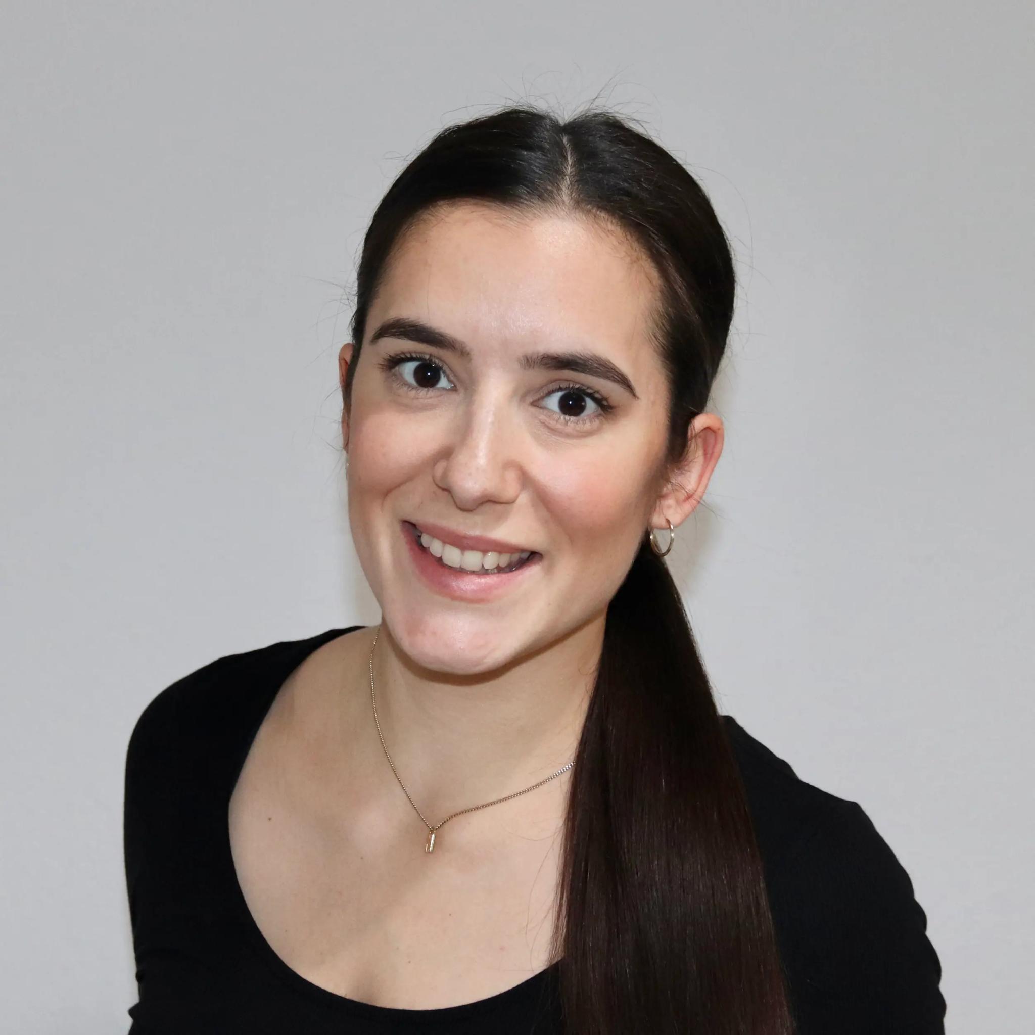 Porträt einer jungen Frau mit dunklen Haaren und schwarzem Oberteil