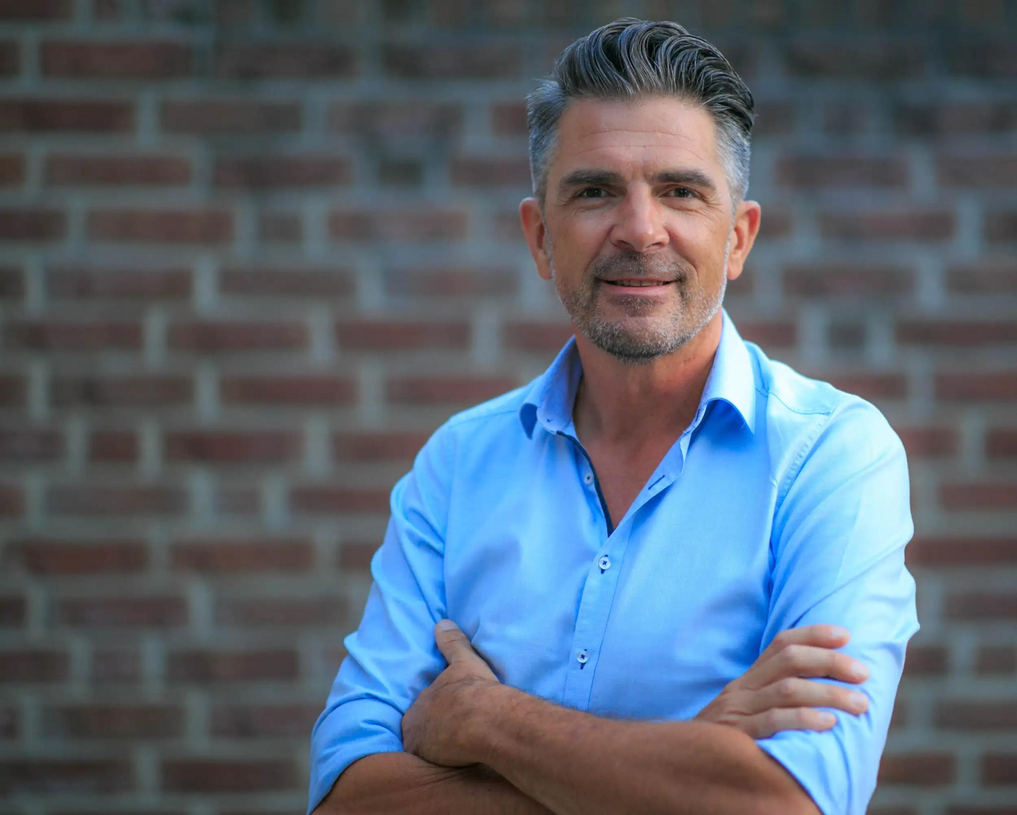 Porträt eines Mannes vor einer Backsteinmauer